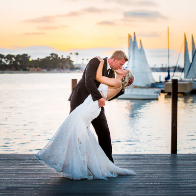 Bride and Groom Kiss on a Sailboat Dock at Sunset