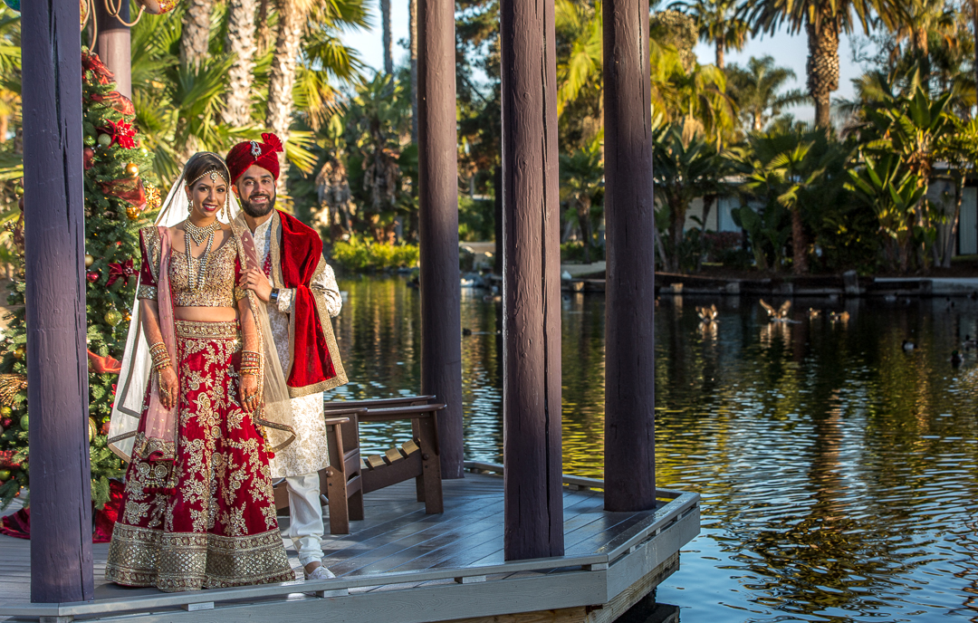 Indian Wedding bride and groom standing by water