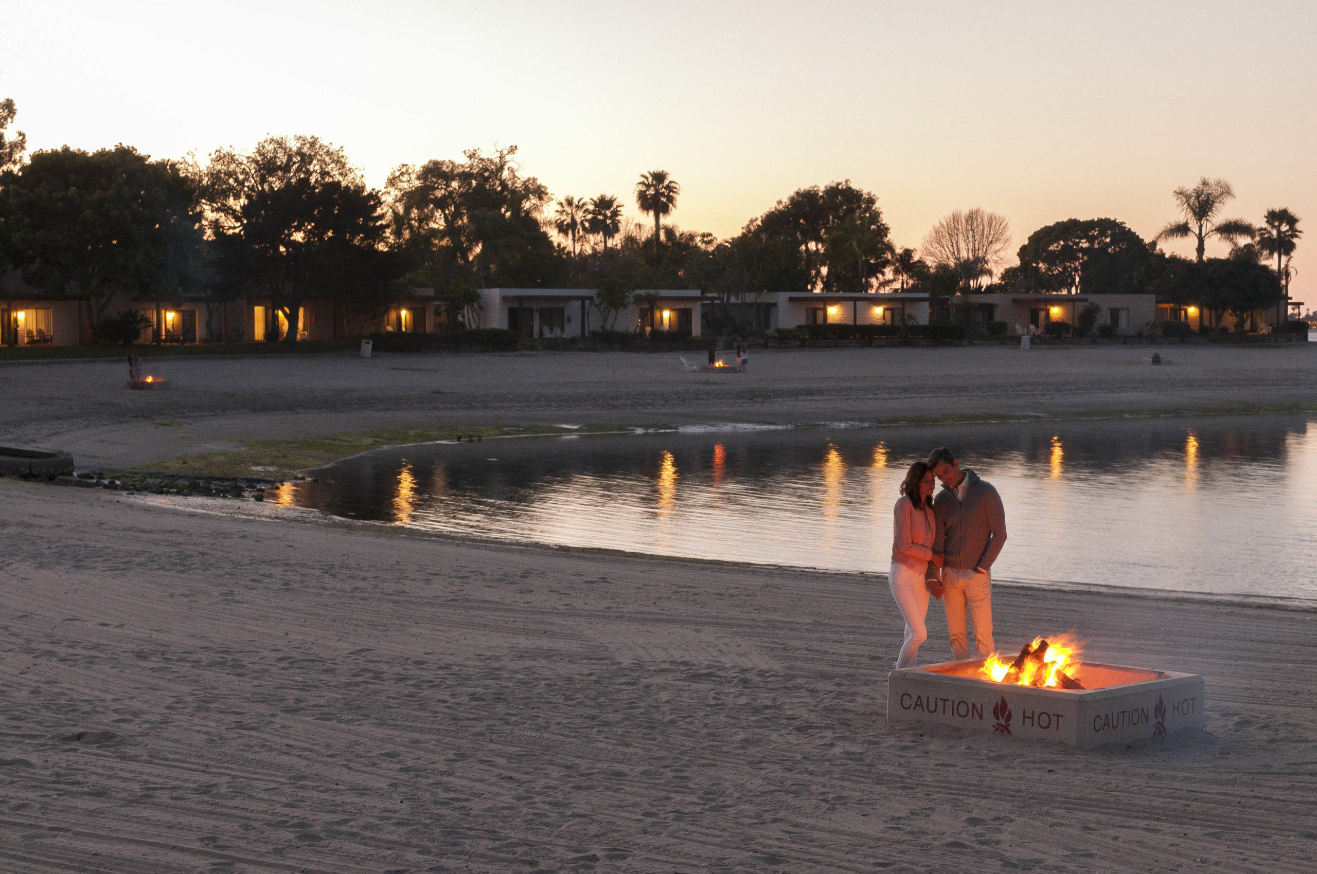 Couple on beach at fire pit