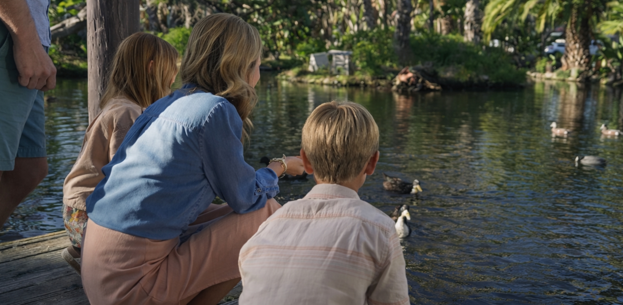 mom and kids feeding ducks